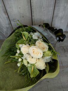 黒のラッピング、白と緑の花の花束